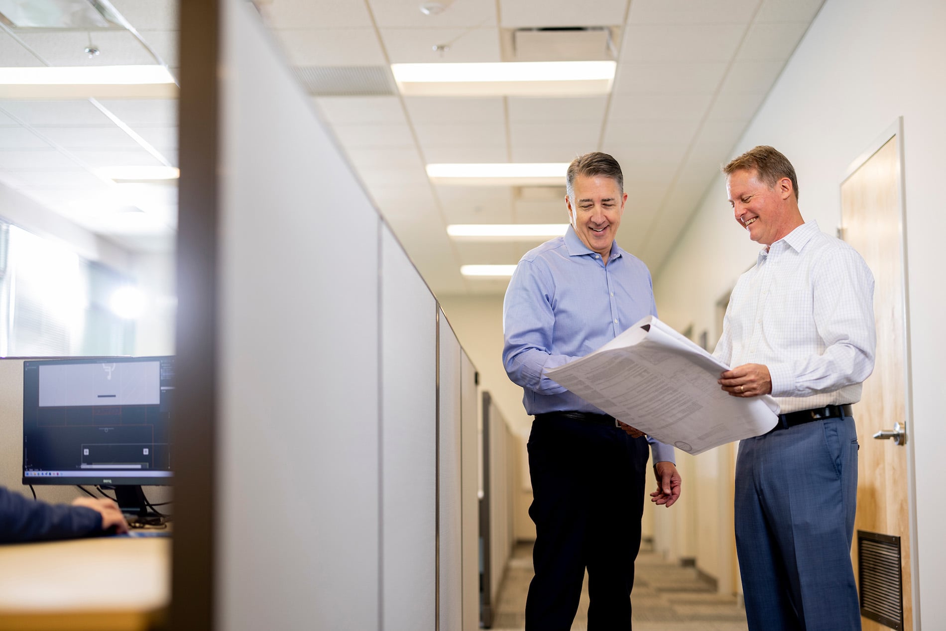 two men looking at a blueprint